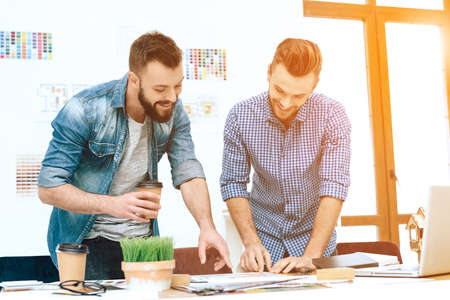 Two designers are standing at table and discussingの写真素材