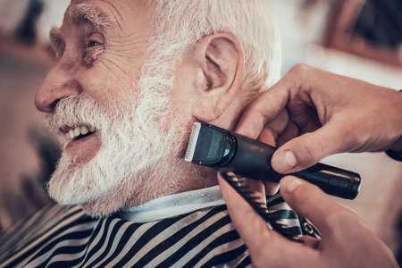 The master cut beard of an old man in barbershop.の写真素材