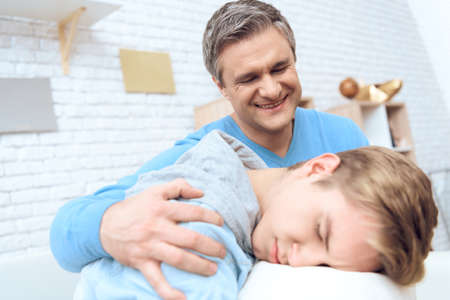 Dad and son at home trying to cheer him up.の写真素材