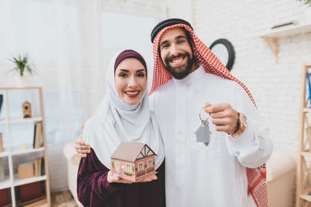 Arab family holds keys to new apartment and smiles
