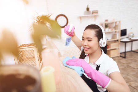 Beautiful asian woman wipes dust off shelves.の写真素材