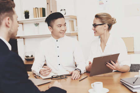 Woman smiles and shows something to a colleague.の写真素材