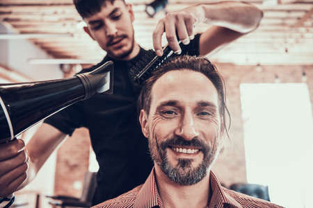 Hairdresser Dries Handsome Mans Hair. Barber Shop.の写真素材