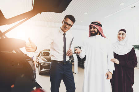 Man advises couple of Arabs in a store on new car.の写真素材