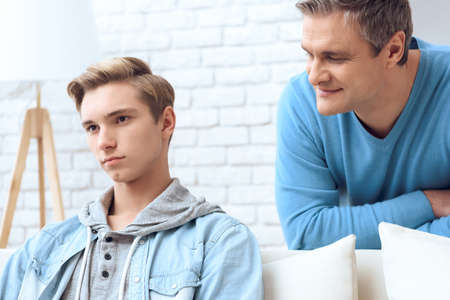 Dad is afraid to talk with a sad son.の写真素材