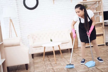 A woman stands in a large room and cleans.の写真素材
