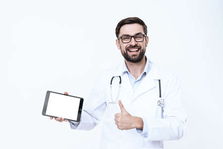 A man stands with a tablet and shows thumb up.の写真素材