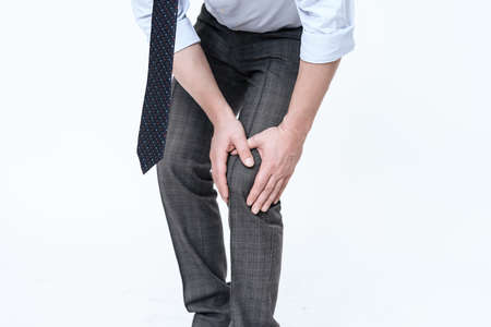 A young man has a pain in his leg.の写真素材