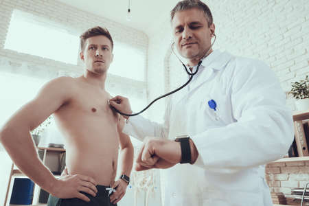 An athlete stands at the doctor in the office.