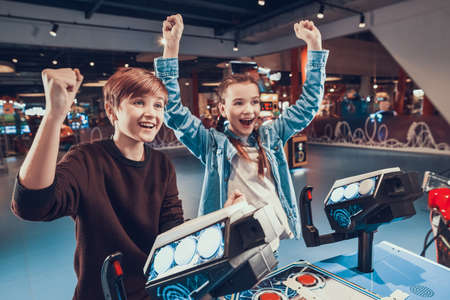 Brother raised hand up and smiles with his sister.の写真素材