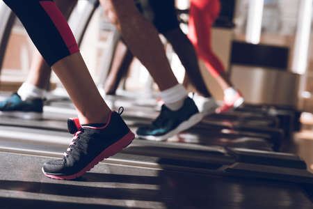 Feet running on a treadmill synchronously.