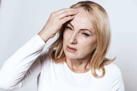 Girl looking at camera and holding on to sore head