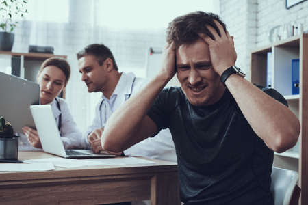 The man clutched his head in pain in the office.の写真素材