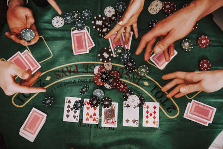 Shooting from above of people playing cards.