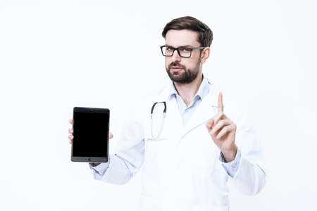 A man looks at the camera and holds a tablet.