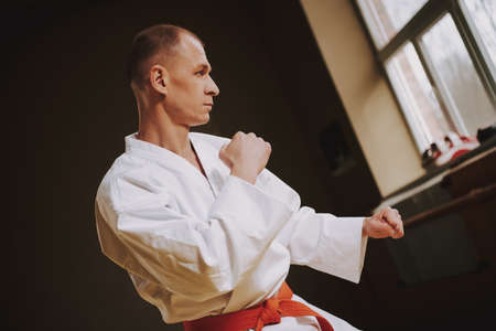 A man with a red belt in karate stands in a rack.の写真素材