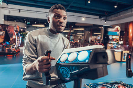 African guy piloting spacecraft in arcade.の写真素材
