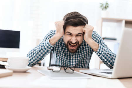 A man in a shirt suffers from headaches.の写真素材