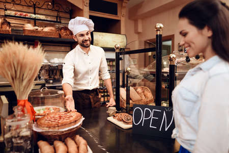 Young Man Selling Bread to Customer in Bakery.の写真素材