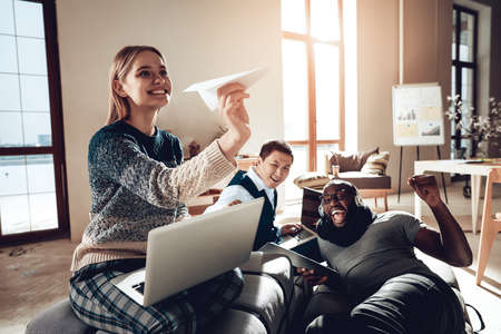 Woman launches paper airplane in creative space.