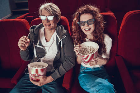Young cheerful couple watching comedy.の写真素材