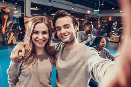 Couple is taking selfie in entertainment center.