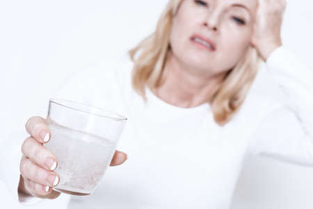 Woman holds out a glass of water.の写真素材
