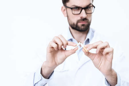 Doctor in a white coat smears a cigarette.の写真素材