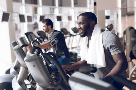 Two men are engaged on treadmills in modern gym.の写真素材