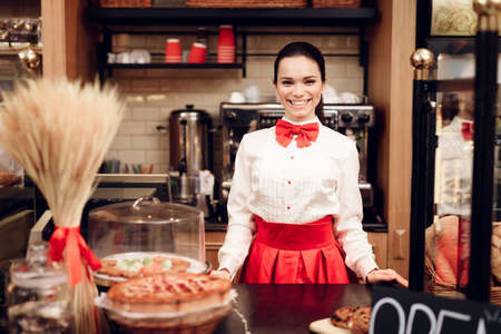 Young Smiling Woman Standing in Modern Bakery.の写真素材