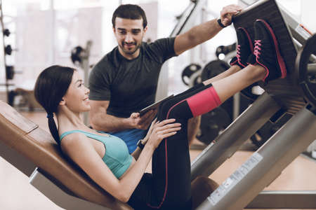 Trainer helps sportswoman in exercise.の写真素材