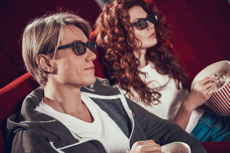 A guy and a woman are sitting in the cinema.の写真素材