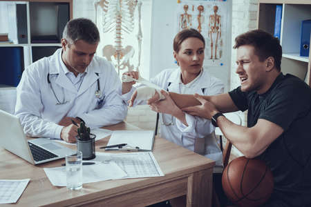 The doctor looks at the patient and bandages arm.の写真素材