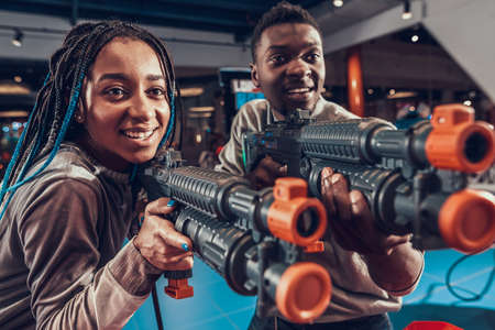 A woman smiles while holding weapon in her hands.の写真素材