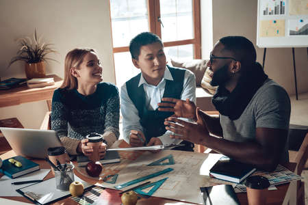 Black man tells something to colleagues in office.の写真素材