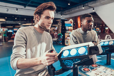 Man with cool hairstyle stands behind a joystick.の写真素材