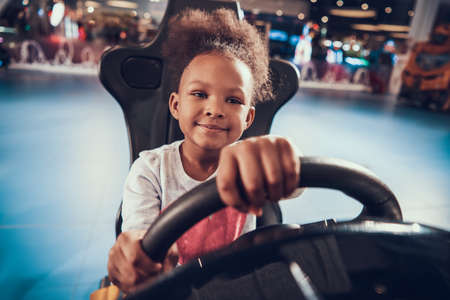 Girl holding wheel while playing virtual racing.の写真素材