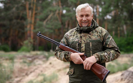 Happy Hunter Old Man in Camouflage with Shotgun.の写真素材