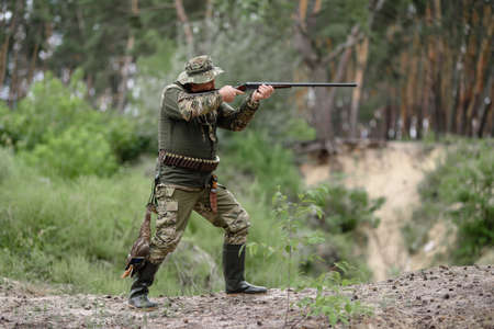 Hunter with Gun at Bird Hunt in Summer Forest.の写真素材
