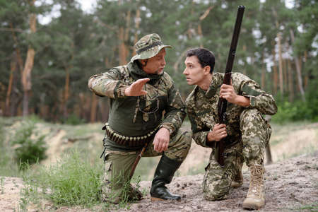 Excited Hunter Teaches Son to Shoot in Forest.の写真素材