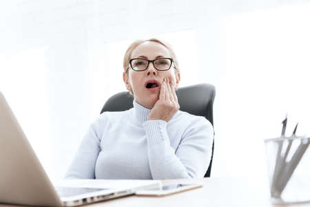 Woman opened her mouth and feels strong toothache.の写真素材