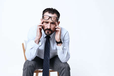 A man sits on a chair with pain.の写真素材