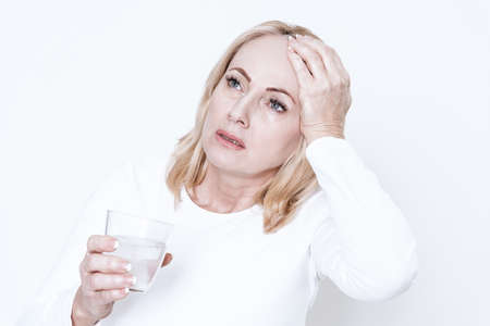 Woman with a glass feels the heat.の写真素材