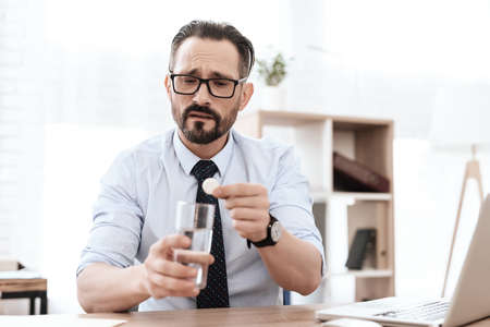 The man is getting ready to drink medicine.の写真素材