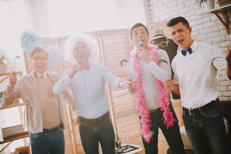 Gay guys singing karaoke songs at party.の写真素材