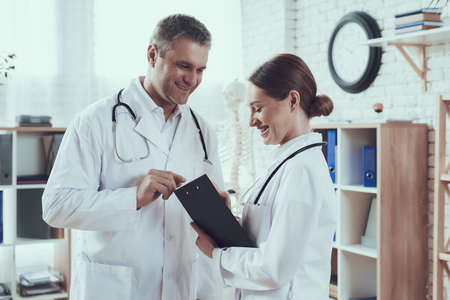 Two doctors look at the notebook and smile.の写真素材