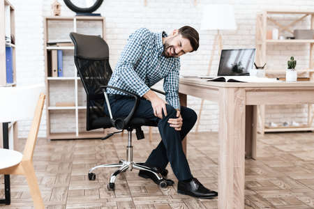 A young man has a pain in his leg.の写真素材