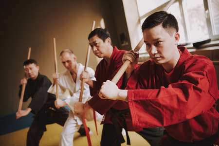Serious man in red kimono holding a stick.の写真素材