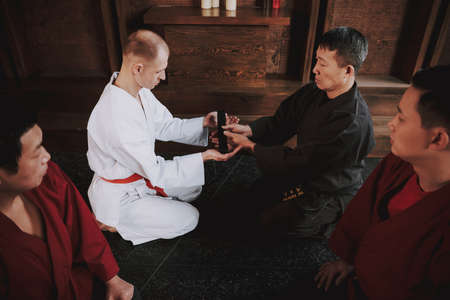 Man in kimono accepts a new belt from a master.の写真素材