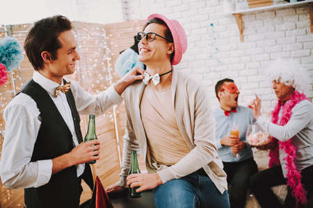Gay guy touching bow tie of another man at party.の写真素材
